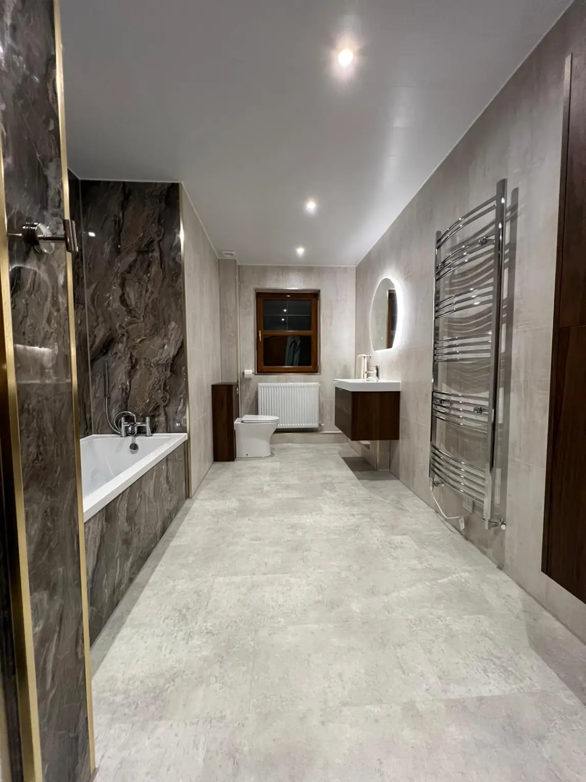 Spacious bathroom with wood furniture and marble-effect finishes