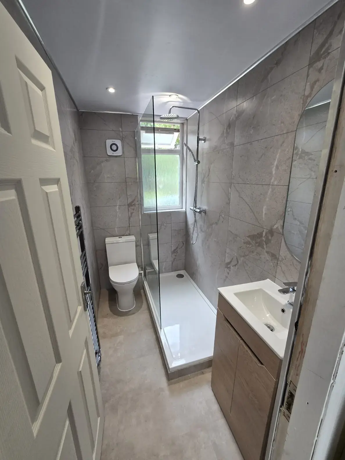 Glass walk-in shower with low tray and wood-effect vanity