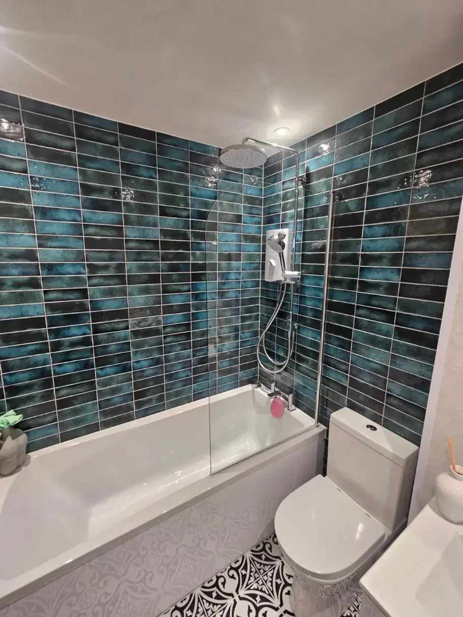 Blue tiled over-bath shower with patterned floor