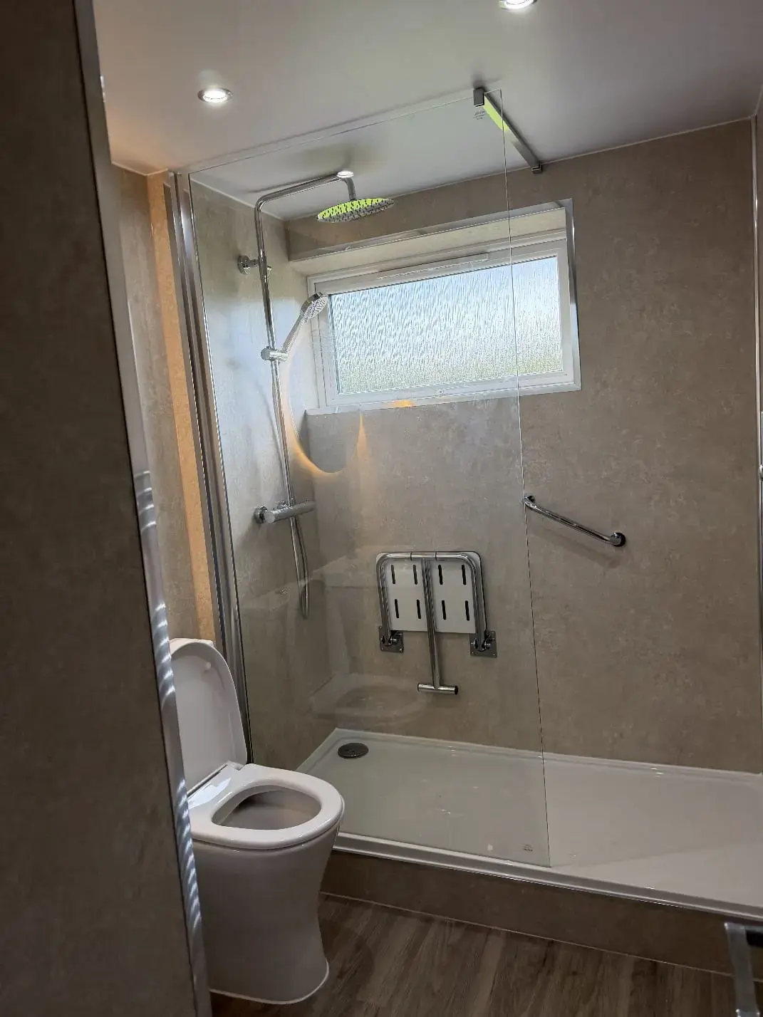 Low-tray shower with folding seat and grab rails
